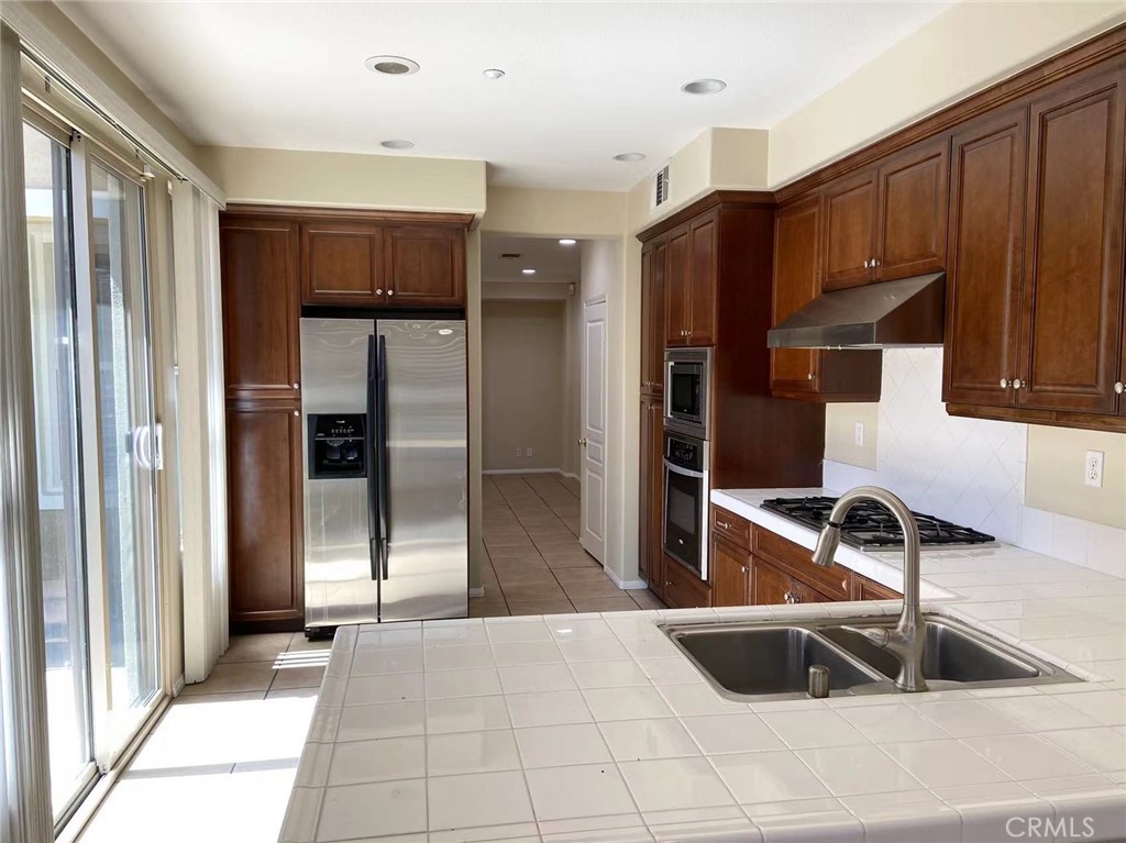 187 Wild Lilac Irvine, CA 92620 - Photo 6 of 16 a kitchen with kitchen island granite countertop a refrigerator and a sink