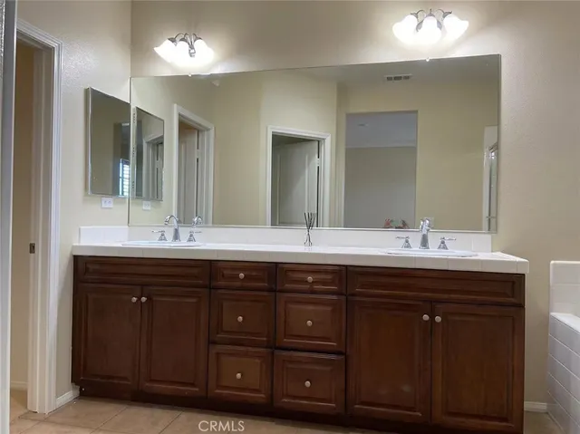 a bathroom with a double vanity sink and a mirror