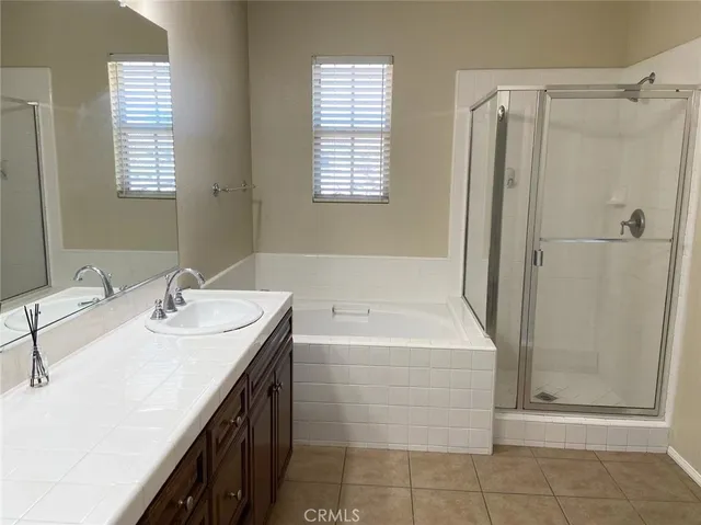 a bathroom with a double vanity sink a mirror and a bathtub