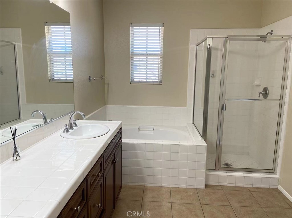 187 Wild Lilac Irvine, CA 92620 - Photo 9 of 16 a bathroom with a double vanity sink a mirror and a bathtub