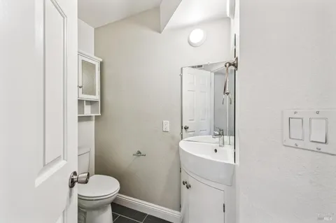 a bathroom with a sink a toilet and a mirror
