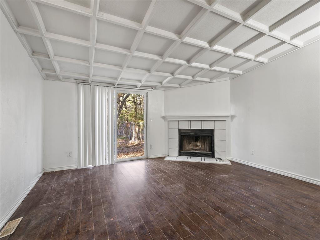 202 Forgotten Lane Mabank, TX 75156 - Photo 5 of 36 a view of an empty room with wooden floor fireplace and a window
