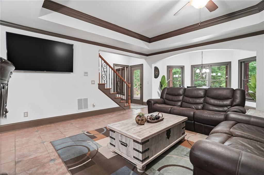 8340 Colonial Place Duluth, GA 30097 - Photo 43 of 74 a living room with furniture a flat screen tv and a floor to ceiling window