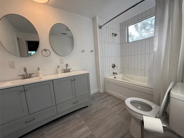 a bathroom with 2 sink a toilet and a mirror