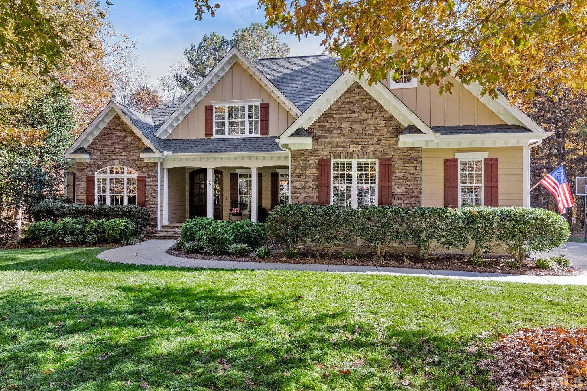a front view of a house with a yard and trees