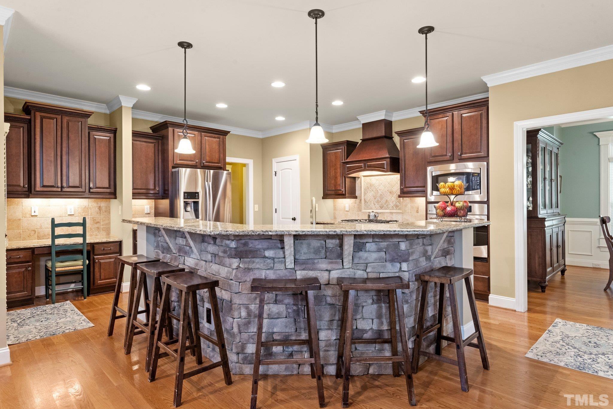 52 Evening Lane Clayton, NC 27527 - Photo 14 of 58 a kitchen with stainless steel appliances granite countertop a kitchen island a stove and a wooden cabinets