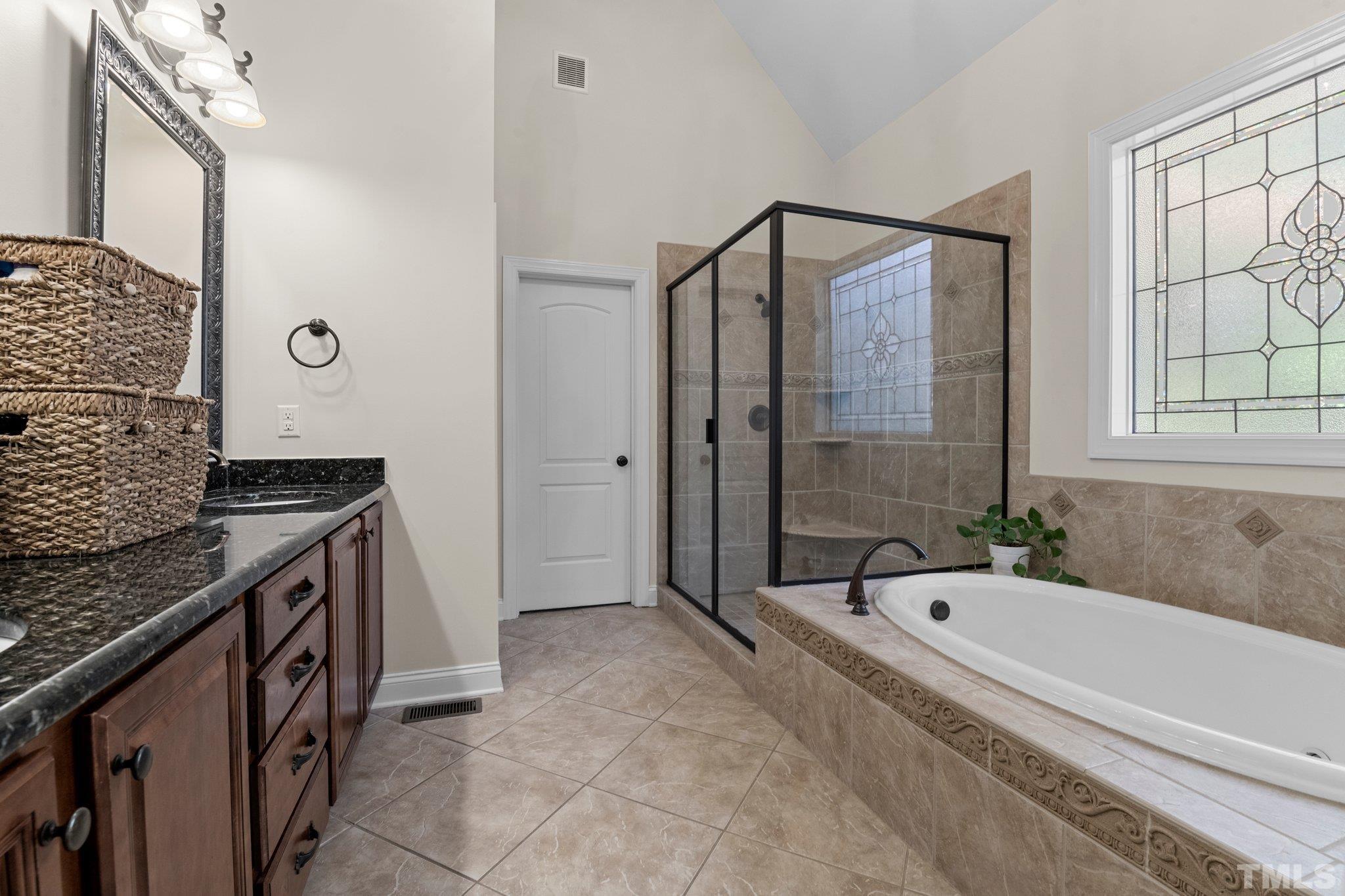 52 Evening Lane Clayton, NC 27527 - Photo 20 of 58 a bathroom with a granite countertop tub shower sink and mirror