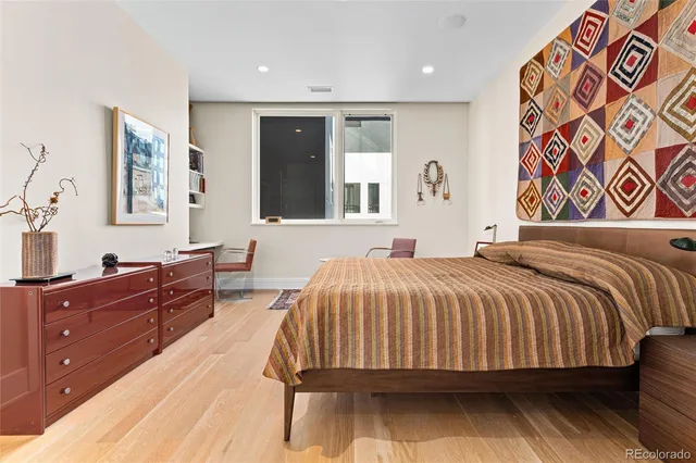 a bedroom with a bed and a painting on the wall