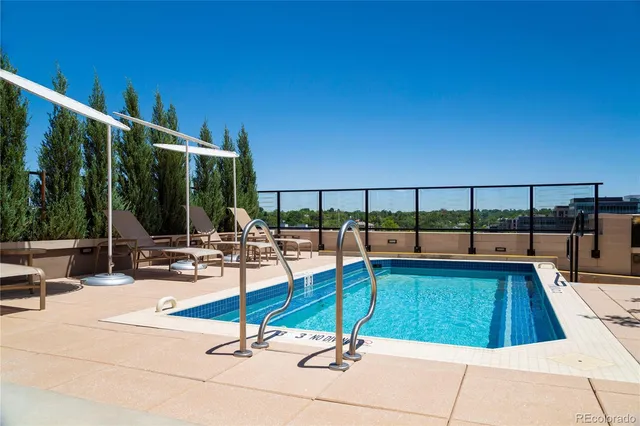 a view of a roof deck with couches and sky view