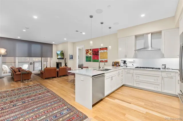 a kitchen with a sink a refrigerator and wooden floor