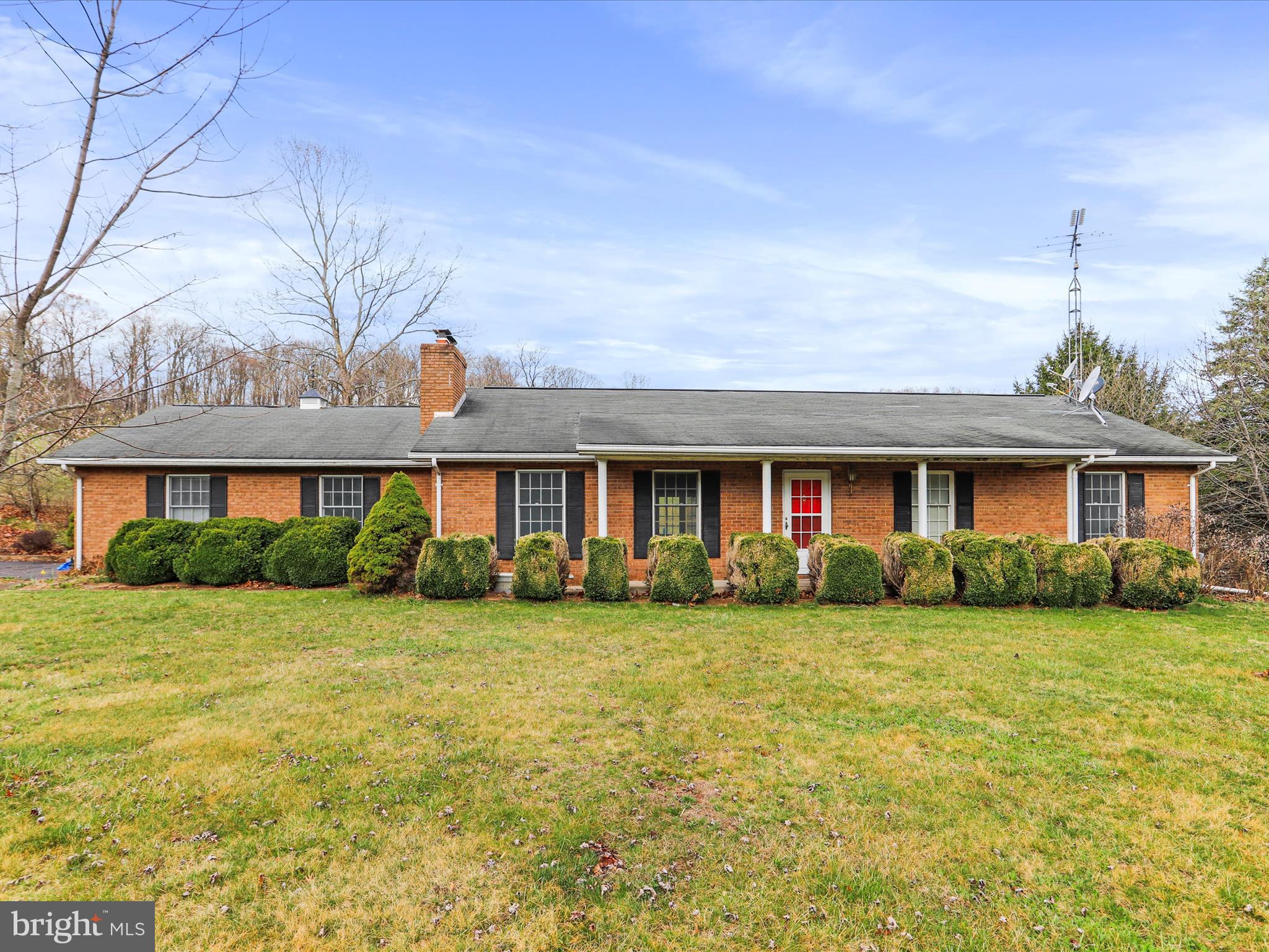 12440 Indian Springs Road Clear Spring, MD 21722 - Photo 5 of 35 a view of a brick house with a big yard and large trees