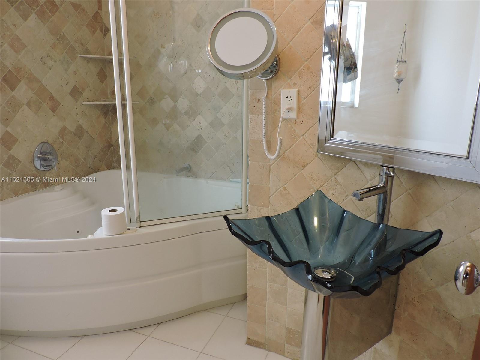 1630 Tyler Street Hollywood, FL 33020 - Photo 12 of 26 a bathroom with a granite countertop sink a toilet and bathtub