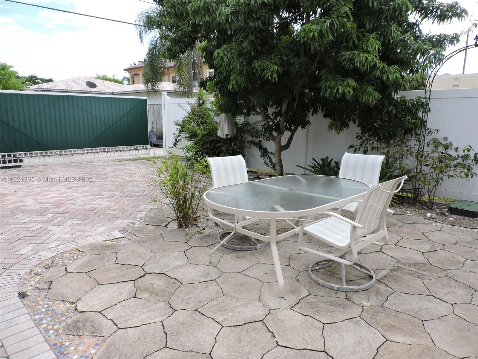 1630 Tyler Street Hollywood, FL 33020 - Photo 18 of 26 a backyard of a house with table and chairs