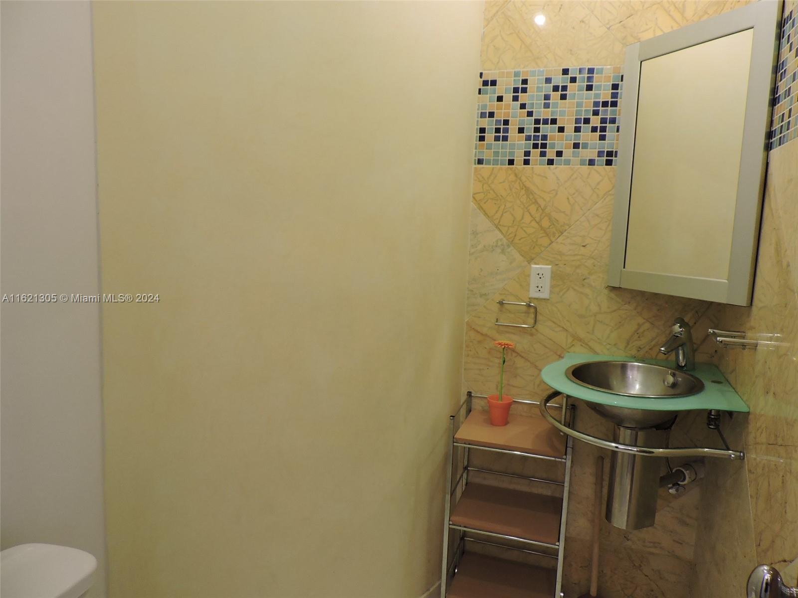 1630 Tyler Street Hollywood, FL 33020 - Photo 22 of 26 a bathroom with a sink and a mirror