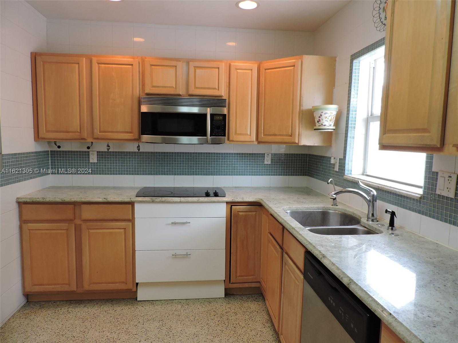 1630 Tyler Street Hollywood, FL 33020 - Photo 23 of 26 a kitchen with granite countertop a sink a stove and cabinets