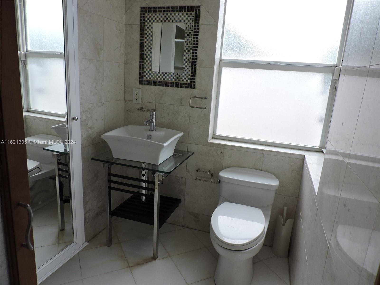 1630 Tyler Street Hollywood, FL 33020 - Photo 4 of 26 a bathroom with a toilet a sink and a window