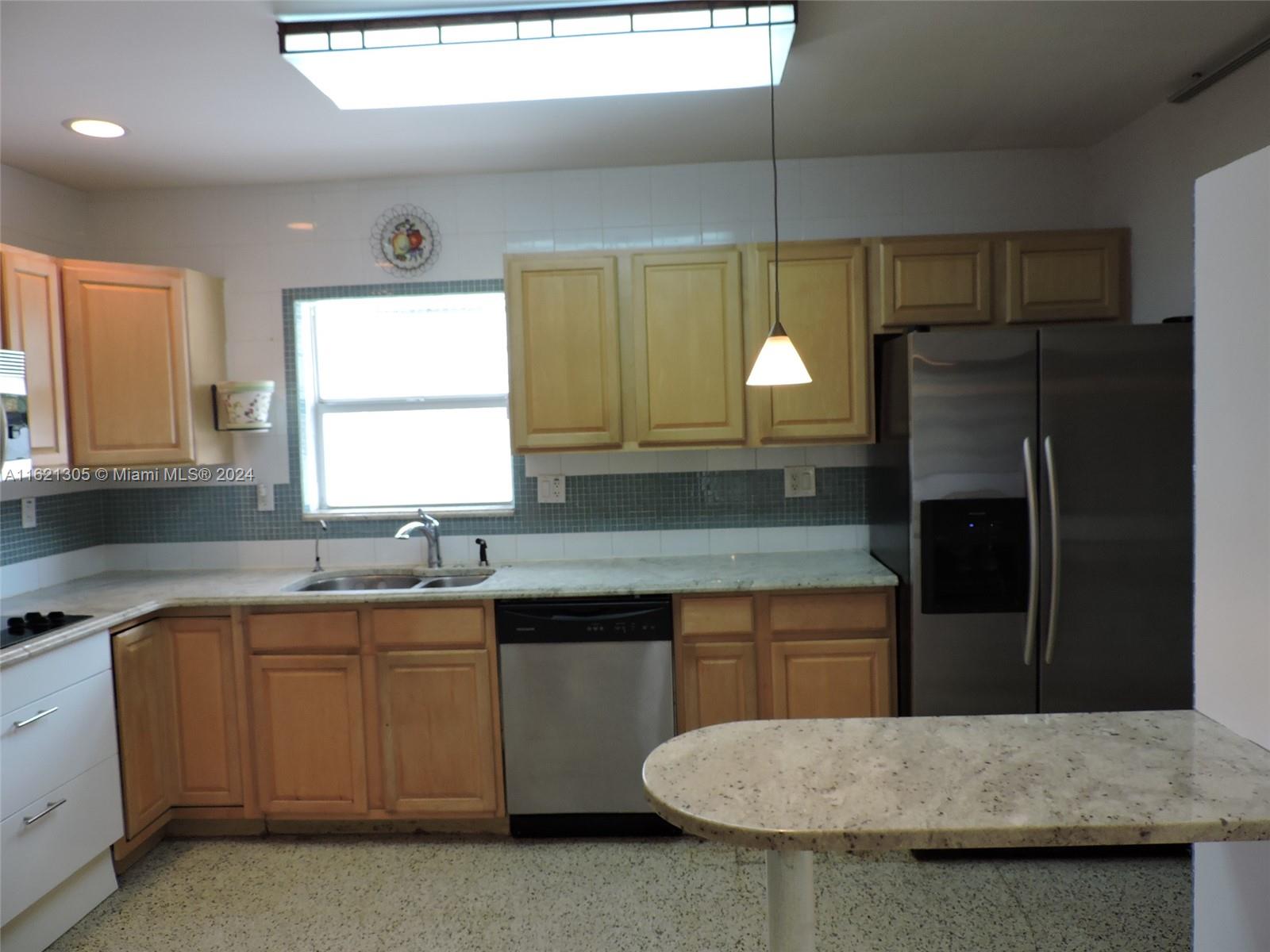 1630 Tyler Street Hollywood, FL 33020 - Photo 6 of 26 a kitchen with a sink a counter top space and stainless steel appliances