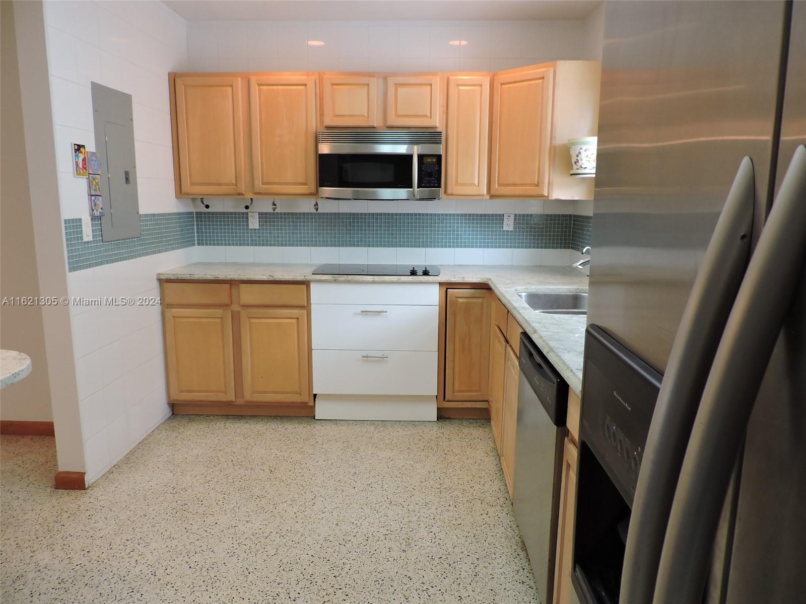 1630 Tyler Street Hollywood, FL 33020 - Photo 8 of 26 a kitchen with stainless steel appliances granite countertop a sink a stove a microwave a refrigerator a sink and dishwasher with wooden cabinets