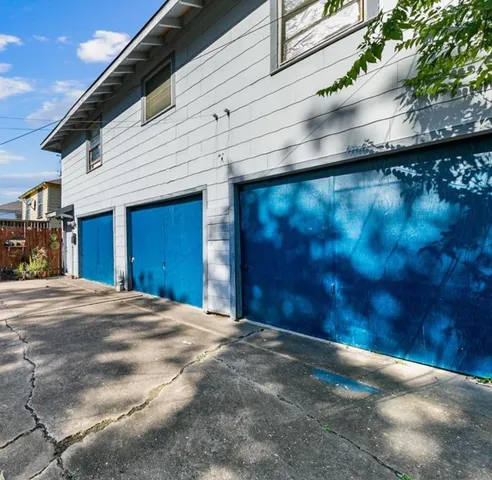 a view of backyard with brick wall and a large tree