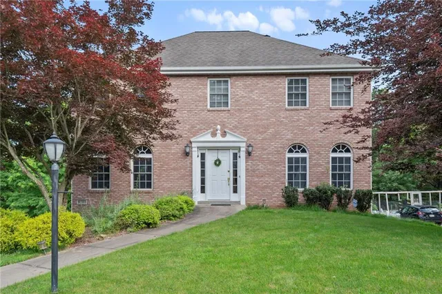 a front view of a house with a yard and trees