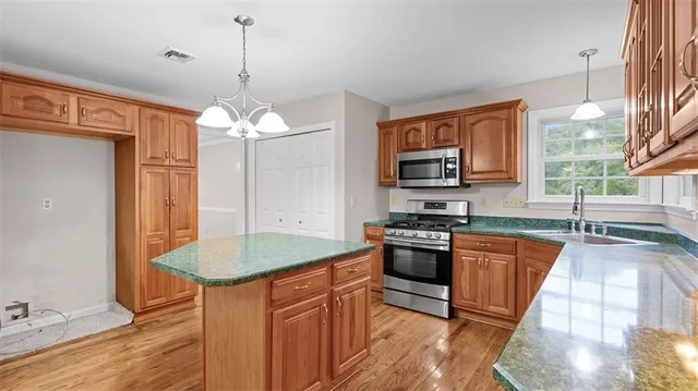 a kitchen with stainless steel appliances granite countertop a sink stove and refrigerator