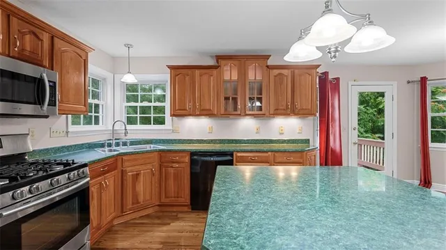 a kitchen with kitchen island granite countertop a stove sink and cabinets