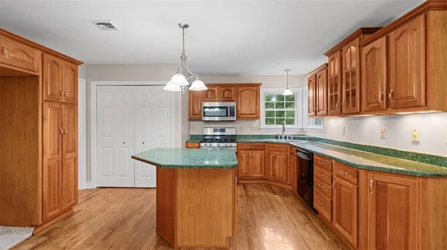 a kitchen with stainless steel appliances granite countertop wooden cabinets a sink and dishwasher