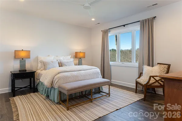 a bedroom with a bed wooden floor and lamp