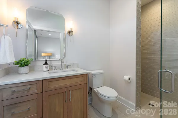 a bathroom with a granite countertop toilet a sink and a mirror