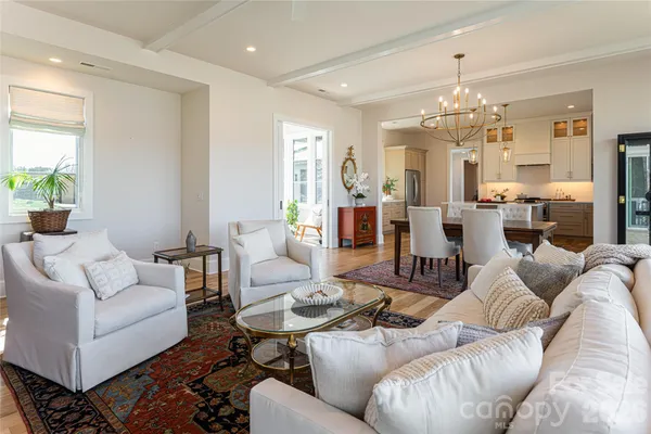 a living room with furniture kitchen and a chandelier