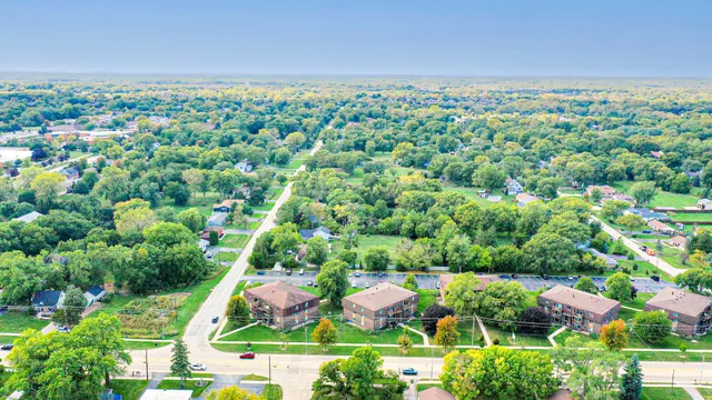 an aerial view of residential houses with outdoor space and trees