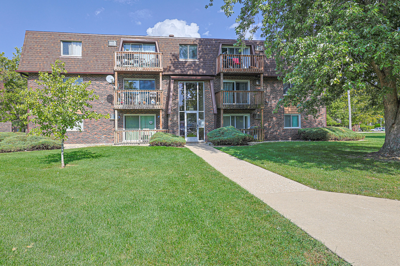 19380 Wolf Road, Unit 6 Mokena, IL 60448 - Photo 3 of 27 a view of a house next to a big yard and large trees