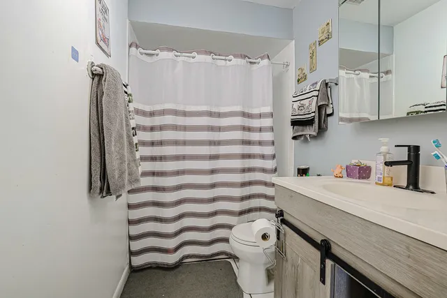 a bathroom with a sink a toilet and shower curtain