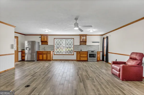 a view of an empty room with window and wooden floor