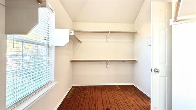 a view of a room with wooden floor and small window