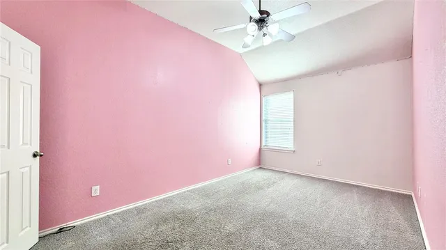 an empty room with a fan & a window