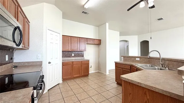 a kitchen with kitchen island granite countertop a sink stove and cabinets