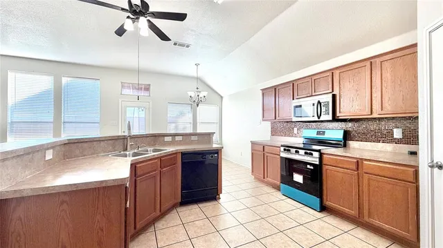 a large kitchen with stainless steel appliances granite countertop a stove sink and cabinets