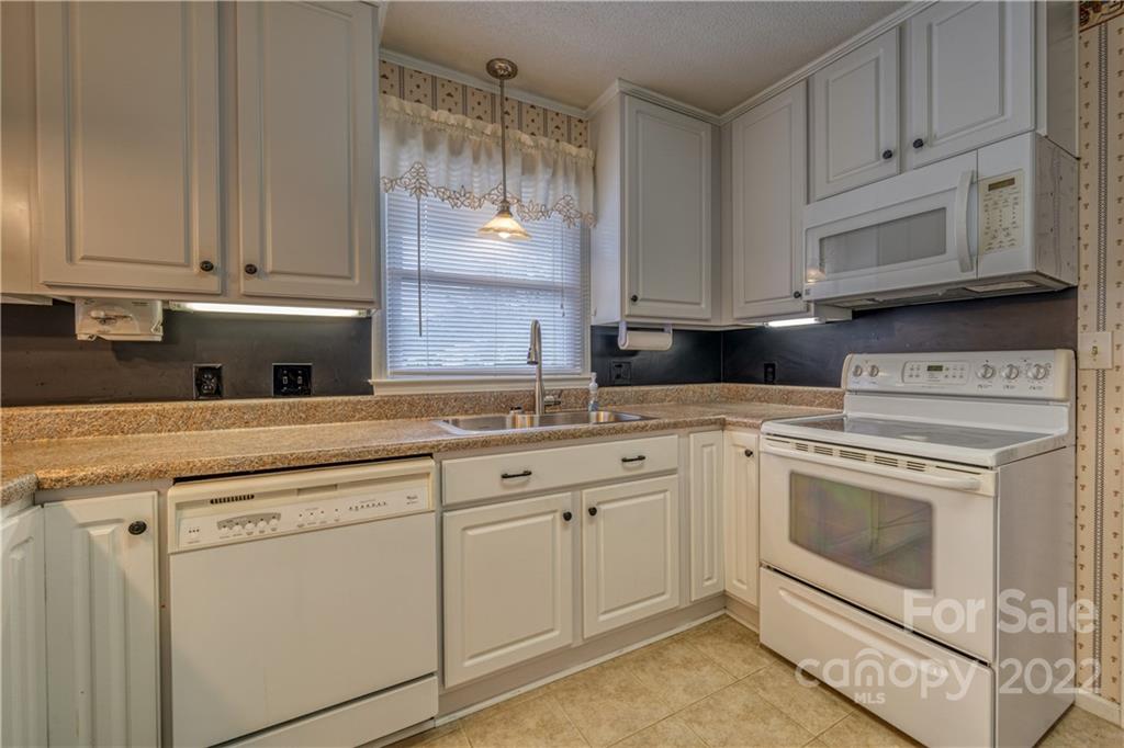 740 Rainey Road Salisbury, NC 28146 - Photo 8 of 32 a kitchen with granite countertop white cabinets and white appliances