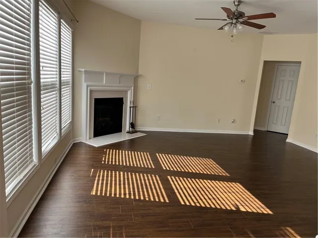 a view of a livingroom with wooden floor and a fireplace
