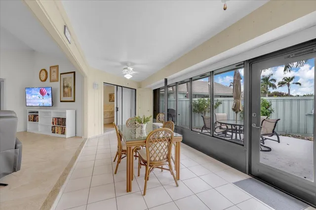 a dining room with furniture and a floor to ceiling window