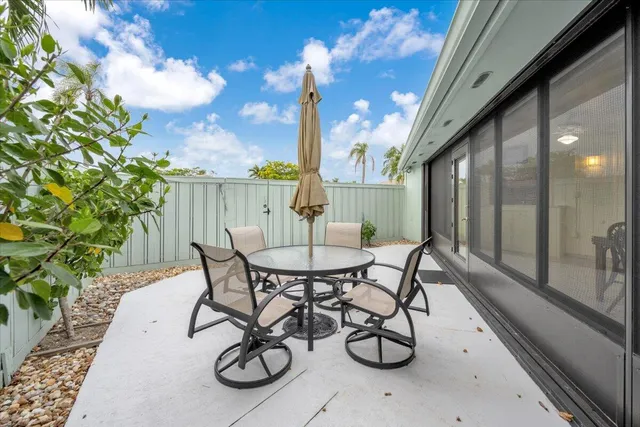 a view of a patio with table and chairs with wooden floor and fence