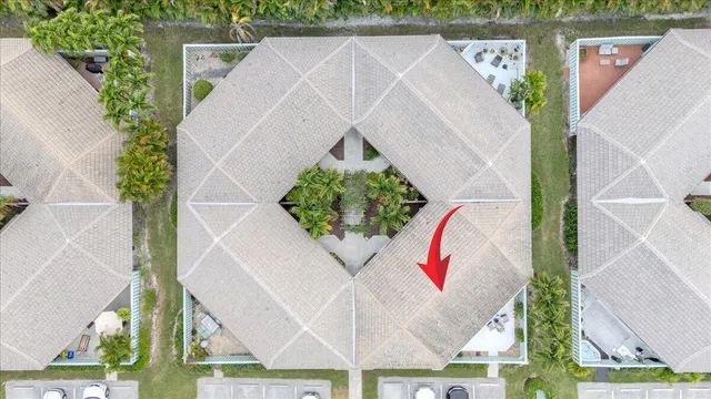 an aerial view of a house with a yard and a large tree