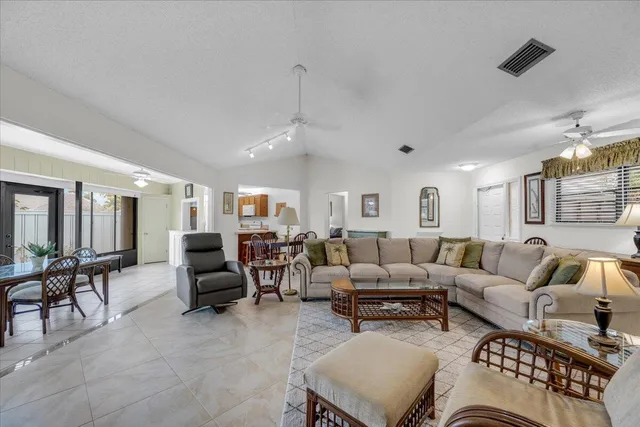 a living room with furniture kitchen view and a large window