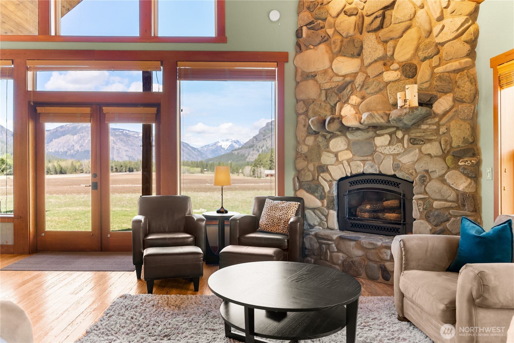 7 Last Chance Road Mazama, WA 98833 - Photo 2 of 40 a living room with furniture a fireplace and a floor to ceiling window