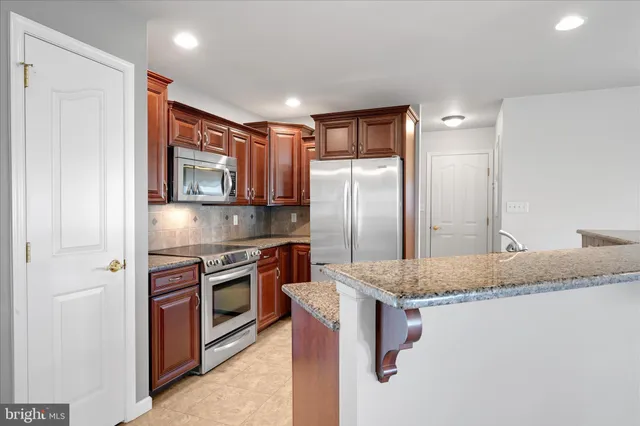a kitchen with stainless steel appliances granite countertop a refrigerator and a sink