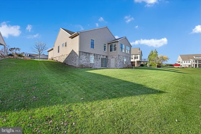 a view of a house with a big yard and large trees