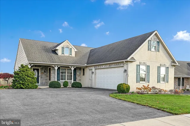 a front view of a house with a garden and plants