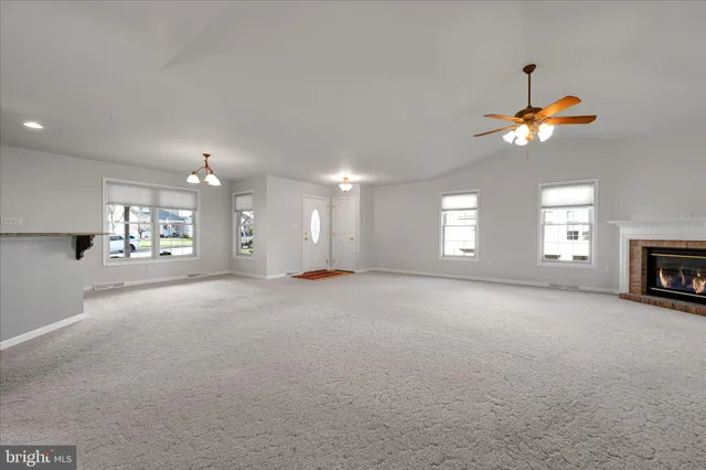 a view of a livingroom with a fireplace a window and a chandelier