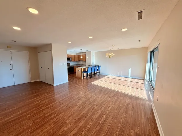 a view of a room with wooden floor and a kitchen